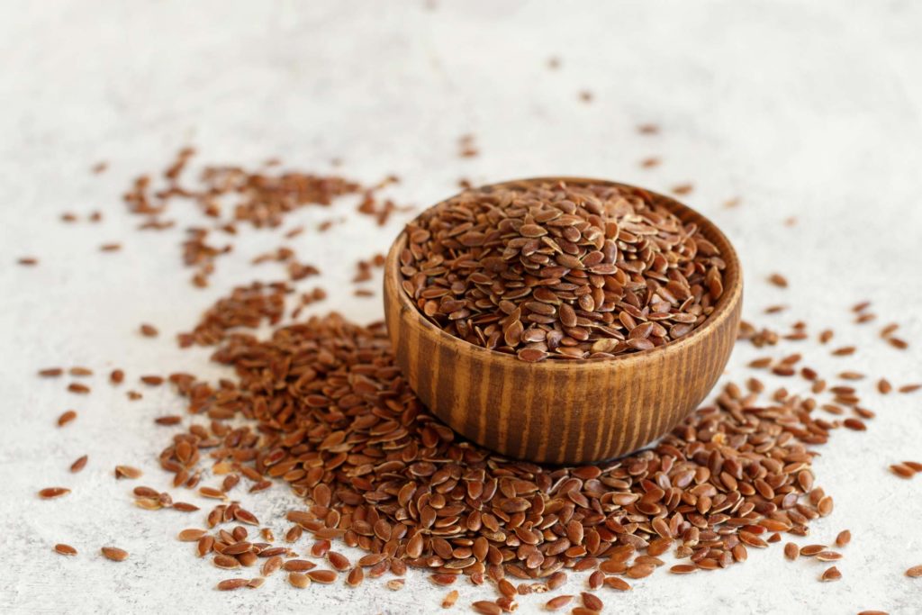 Brown flaxseeds in a bowl and on a counter