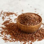 Brown flaxseeds in a bowl and on a counter