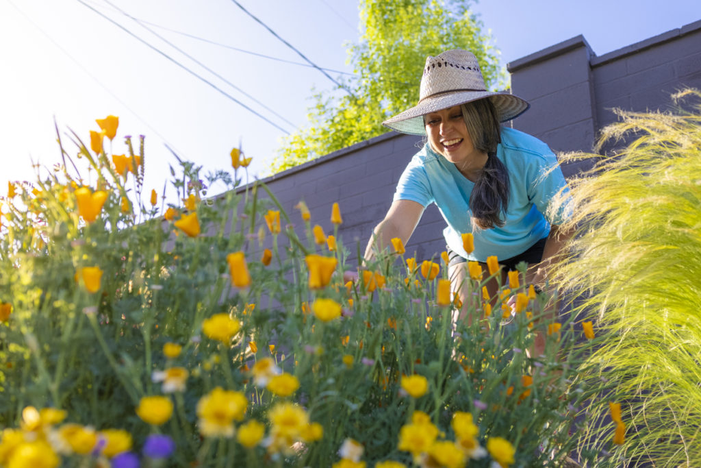 Woman gardening outside with flowers