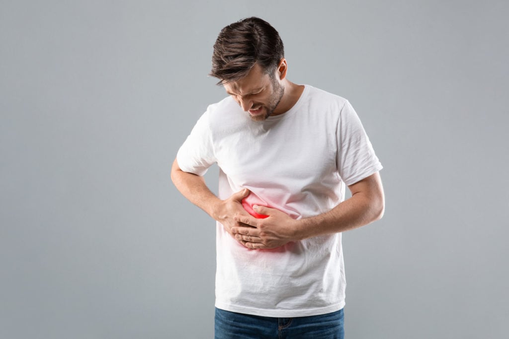 Man suffering from liver pain, holding his abdomen