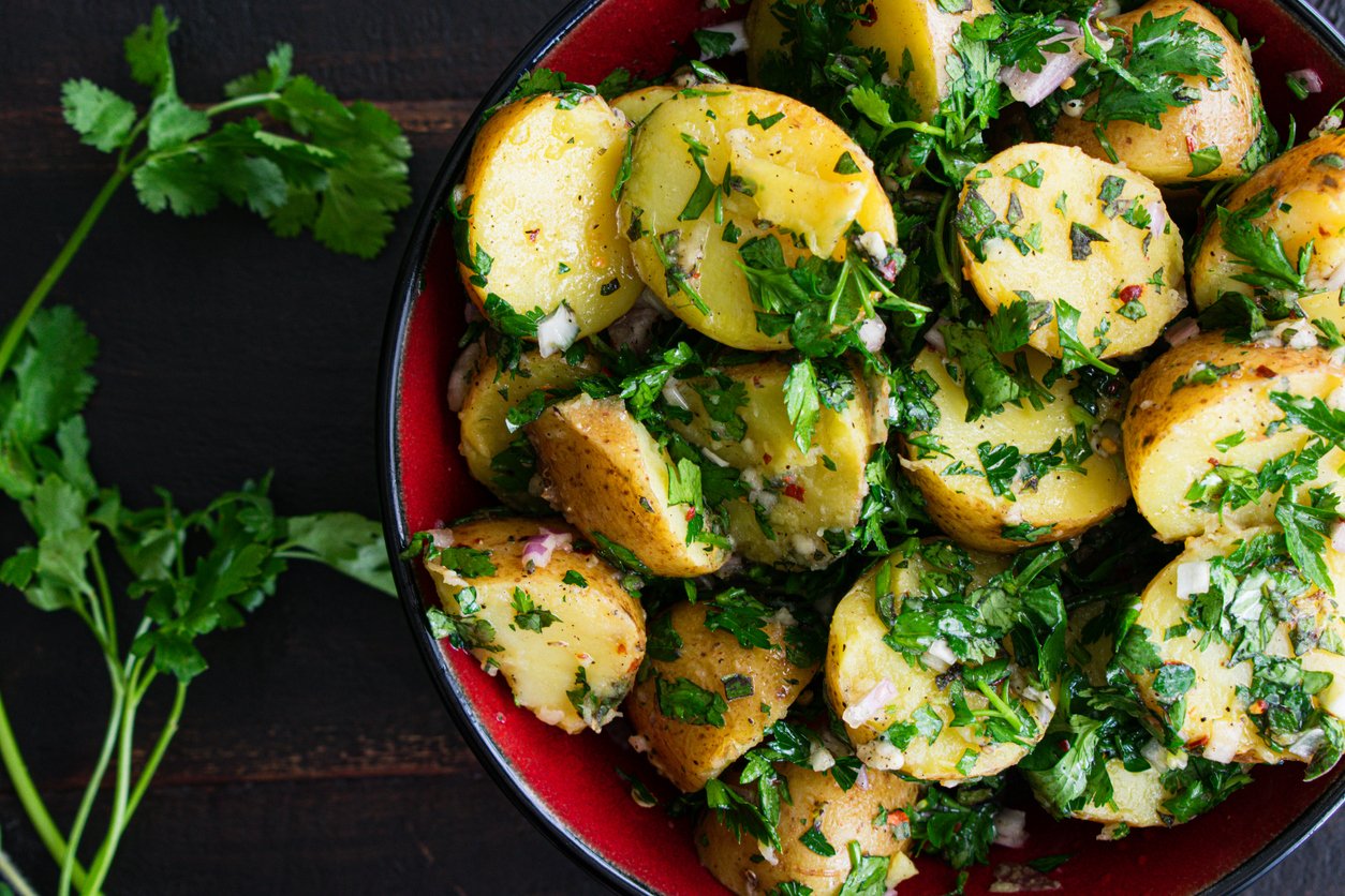 A bowl of potato salad made with mini yellow potatoes and chimichurri sauce