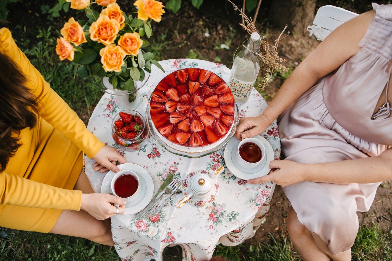 Two women holding teacups on the garden table