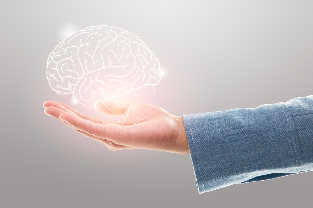 Female doctor holding brain illustration against the gray background. Mental health protection and care