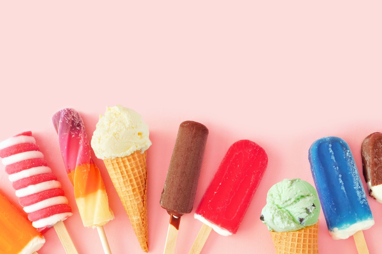 收集豐富多彩的夏季冷凍甜點。粉紅色背景上的頂視圖底邊框。複製空間。