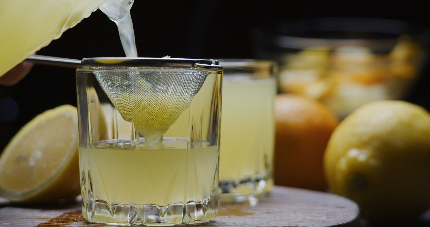 Preparing homemade Turkish lemonade with frozen orange and lemon. Close-up side view