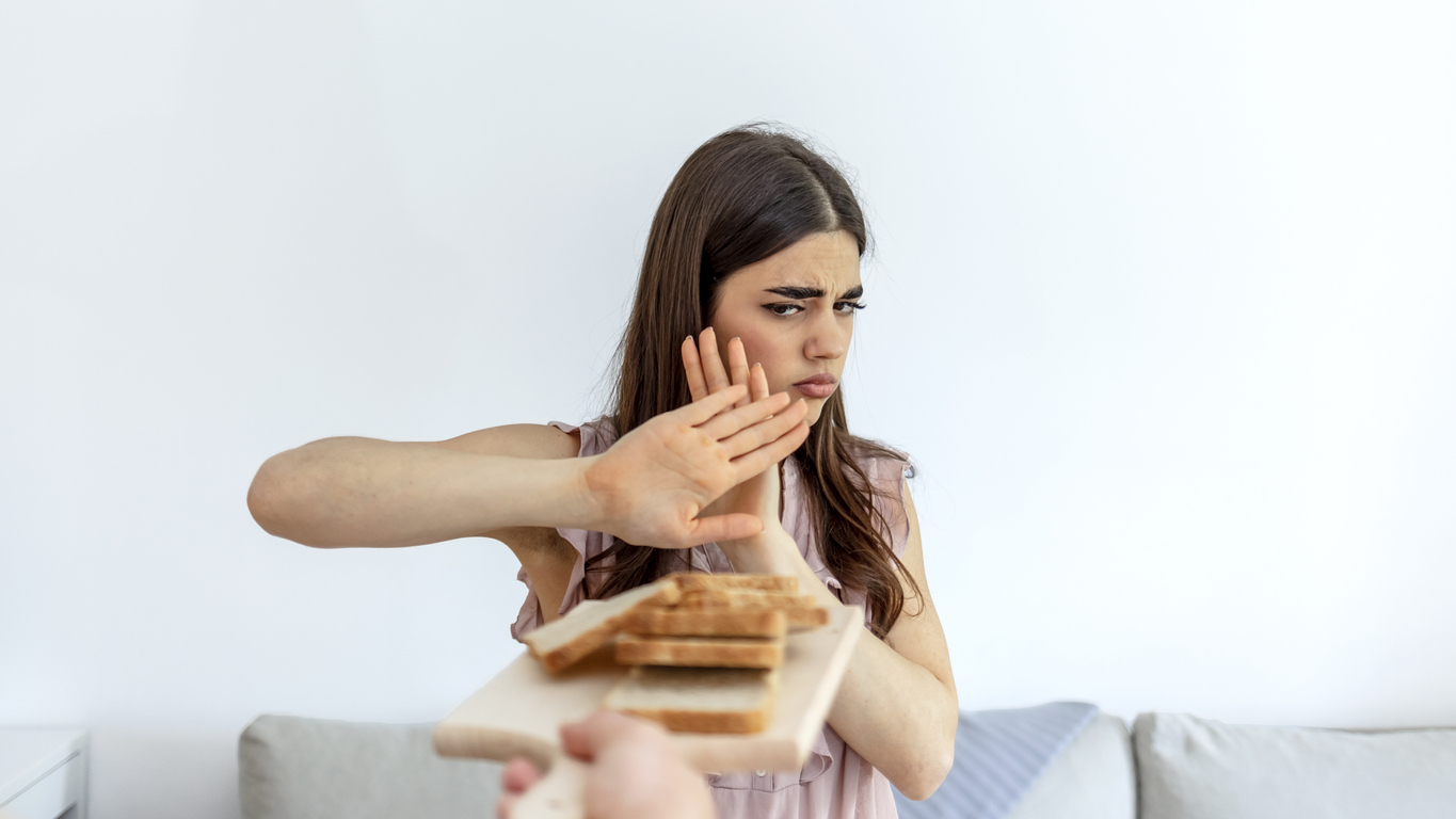 Woman refusing to eat white bread.