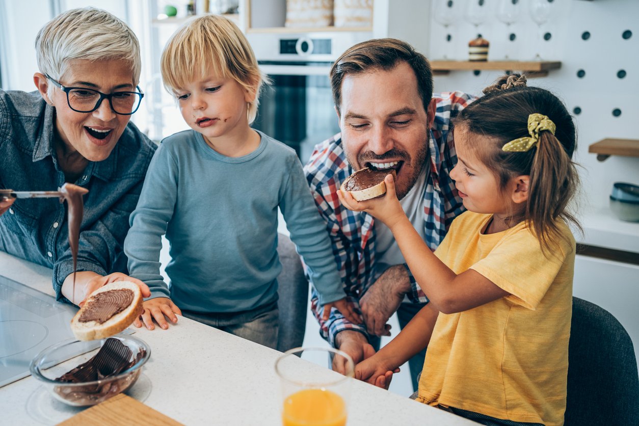 Three generation family having breakfast together in kitchen at home.