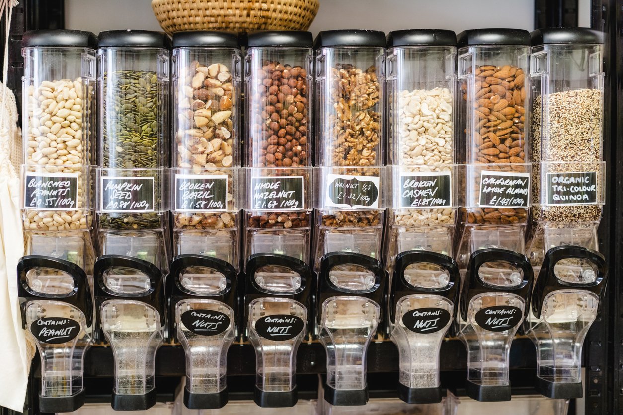 Eco-friendly zero waste shop. Dispensers for cereals, nuts and grains in sustainable plastic free grocery store. Bio organic food. Shopping at small local businesses. New trend alternative buying