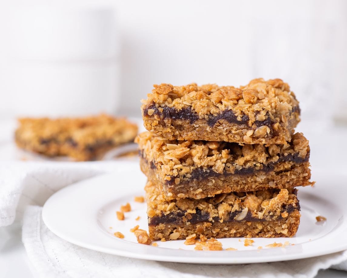 Date squares (or Matrimonial cake) stacked on a plate in a white kitchen