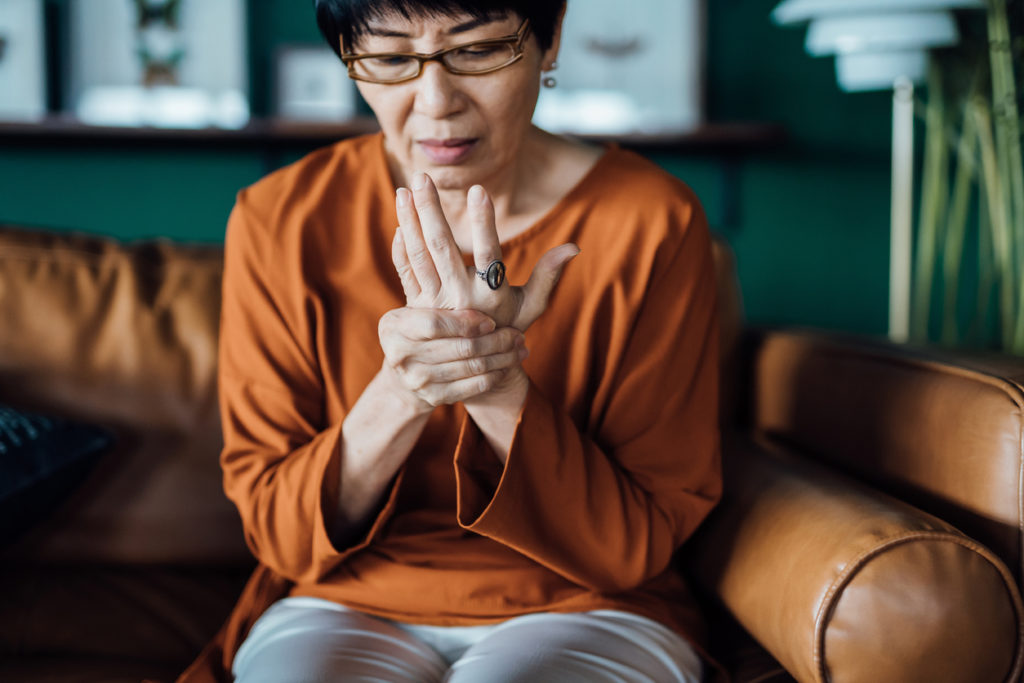 Older Asian woman suffering from rheumatoid arthritis