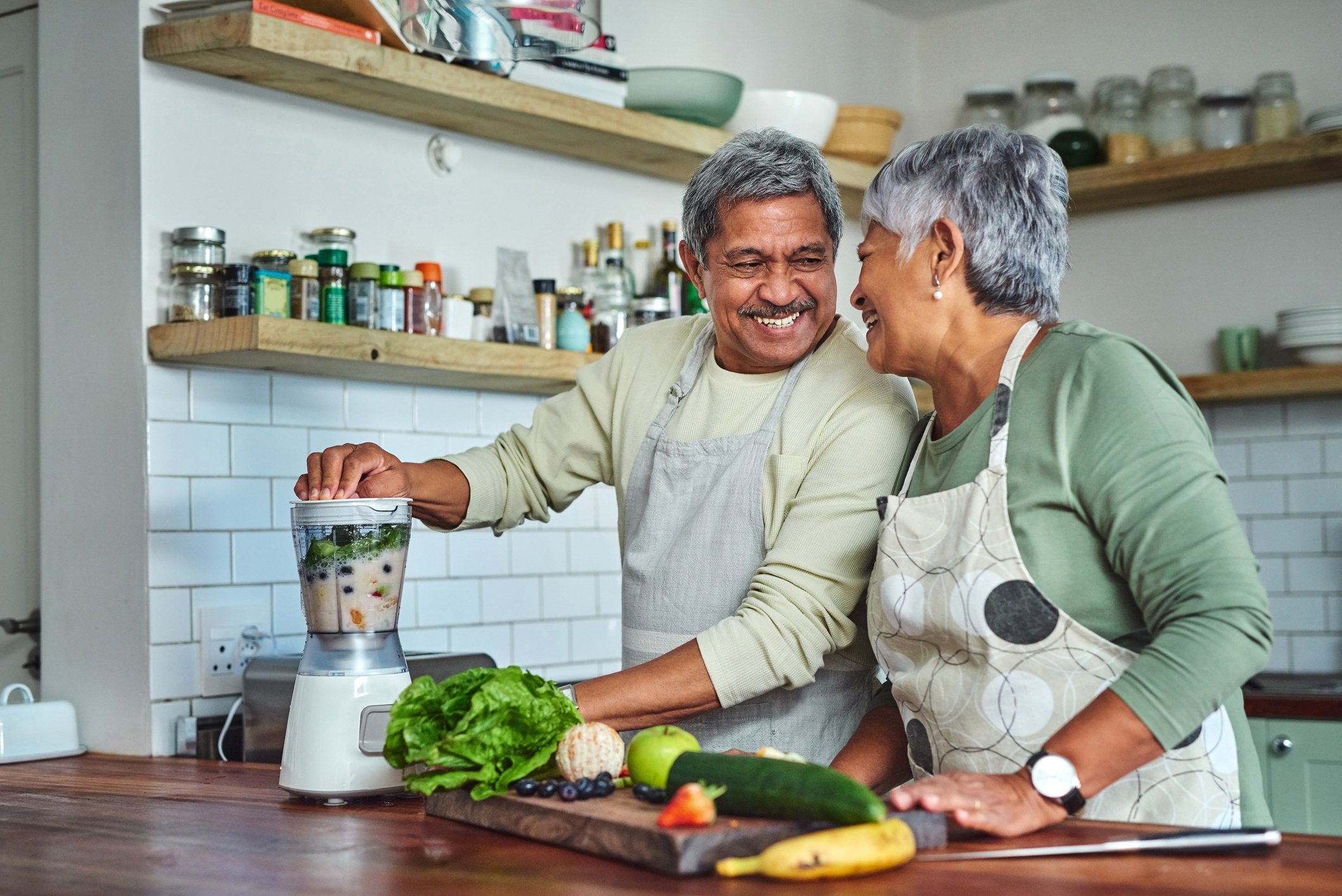 Senior couple preparing a healthy breakfast smoothie in the kitchen