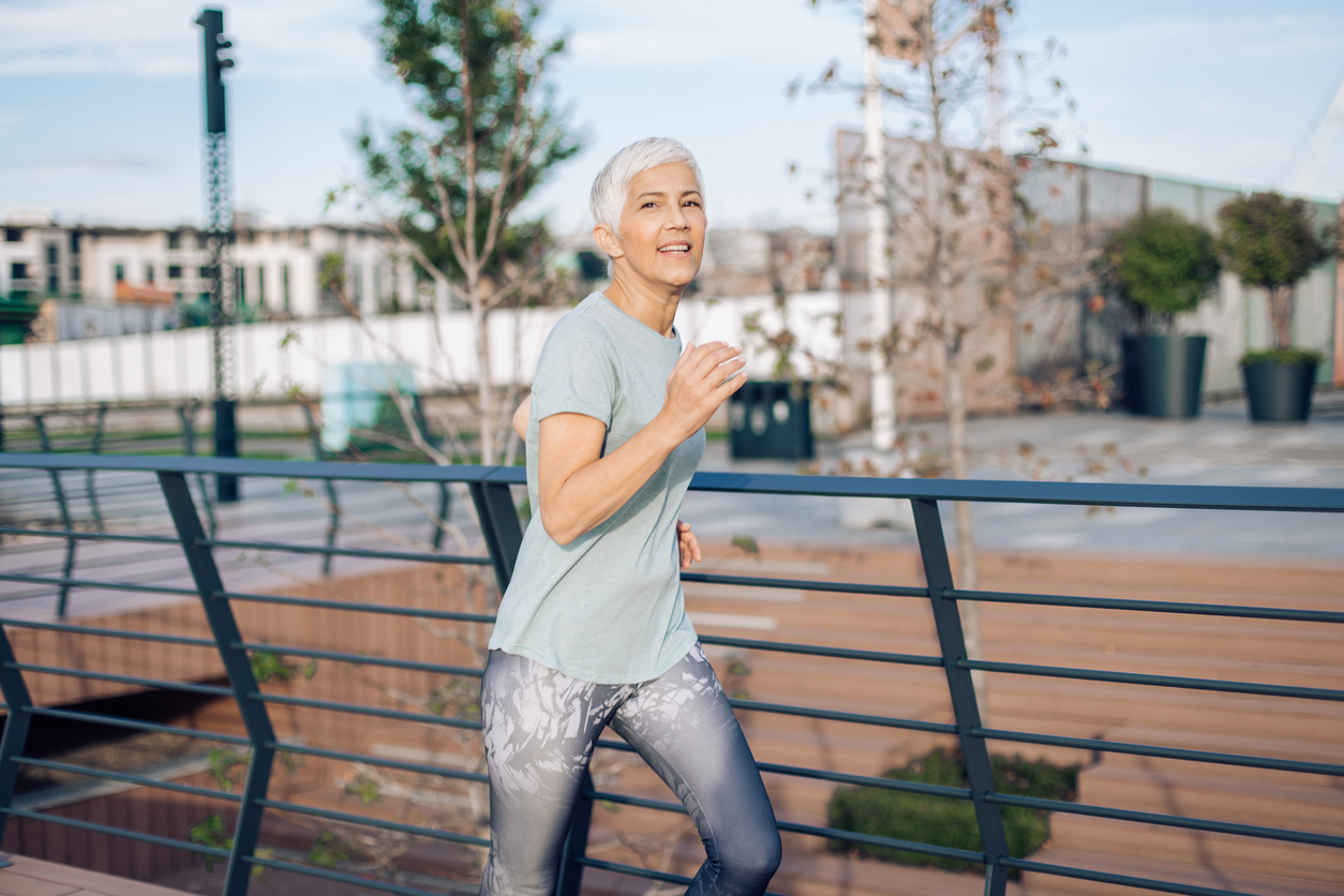 Happy senior woman jogging outdoors.