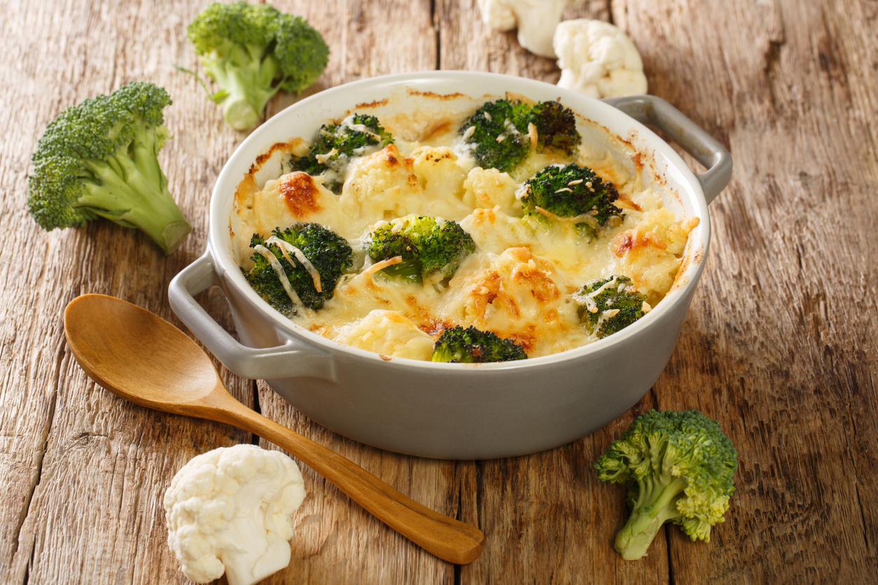 Homemade delicious creamy broccoli cauliflower vegetable casserole close up in a pot on an old table. horizontal