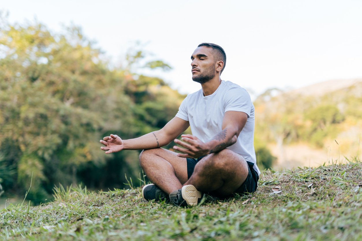 Athlete meditating in the public park on a sunny day