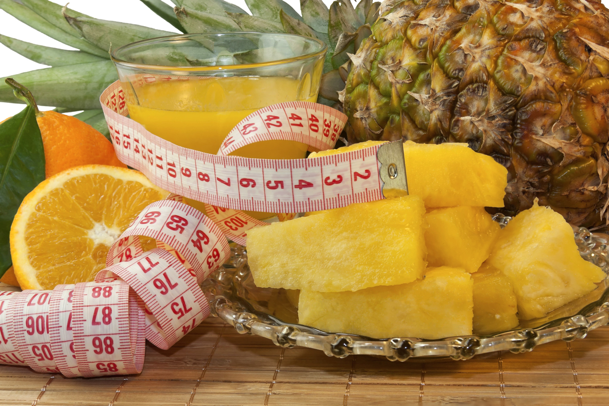 The dessert of fruit, a glass of juice and centimeter close-up on the table