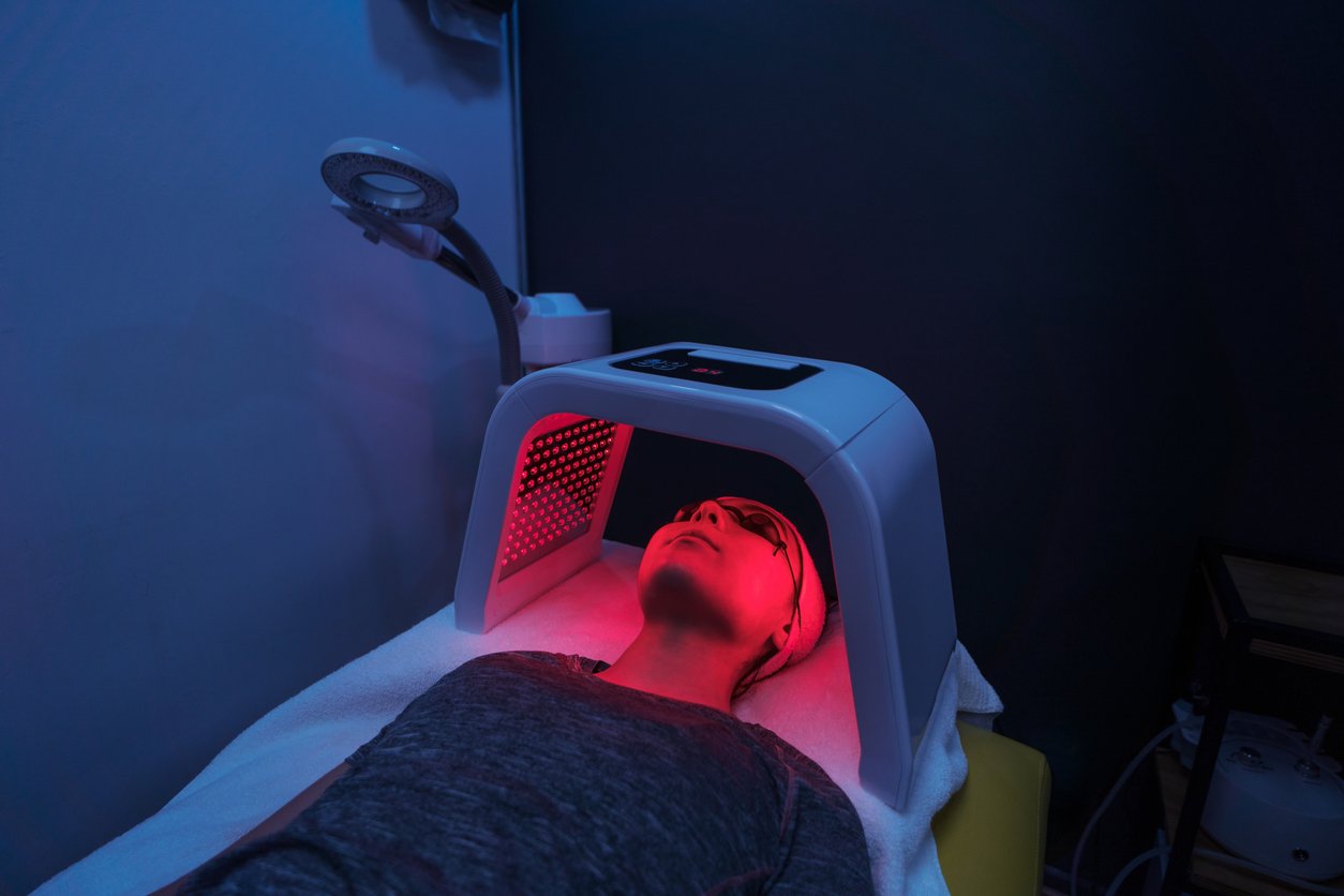 A young woman getting red light therapy done to her face