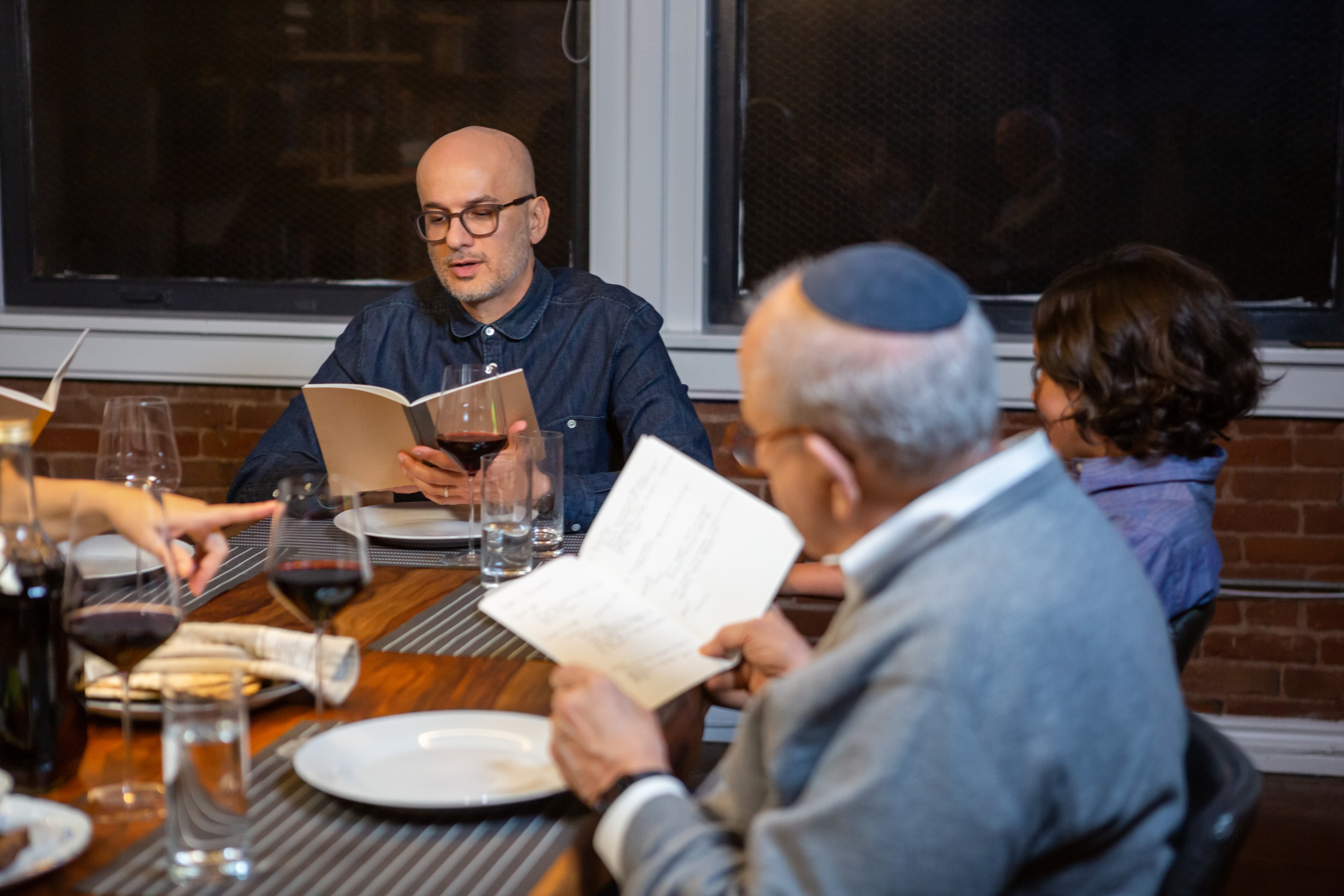 A modern Jewish American family celebrates Passover together, with the seder leader reading from the Haggadah, the text that sets forth the order of the Seder and the story of the Exodus.