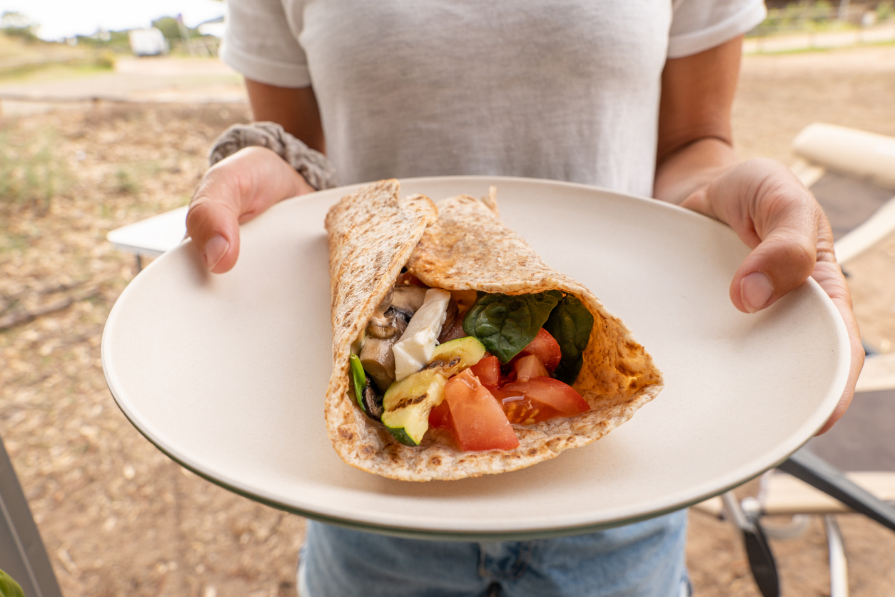Young woman holding a Vegan wrap in a plate