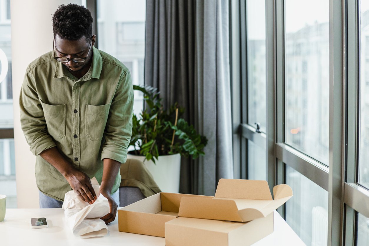 Young man unboxing online purchase in the living room