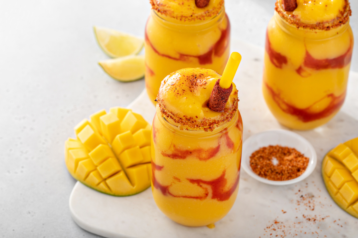 Mangonada mexican mango smoothie with chamoy sauce and chili lime seasoning and tamarind candy straw