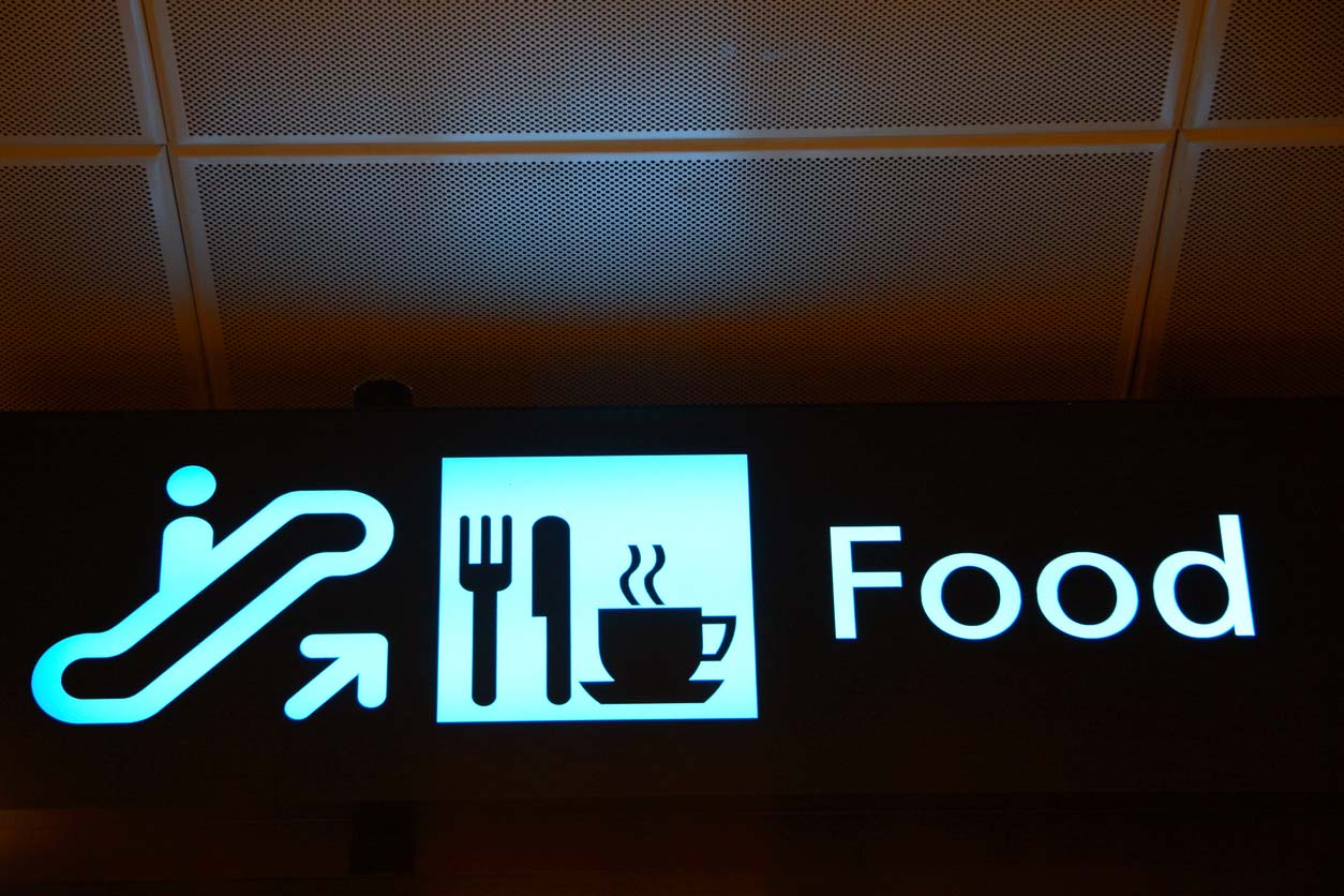 illuminated sign with pictograms of escalator and food