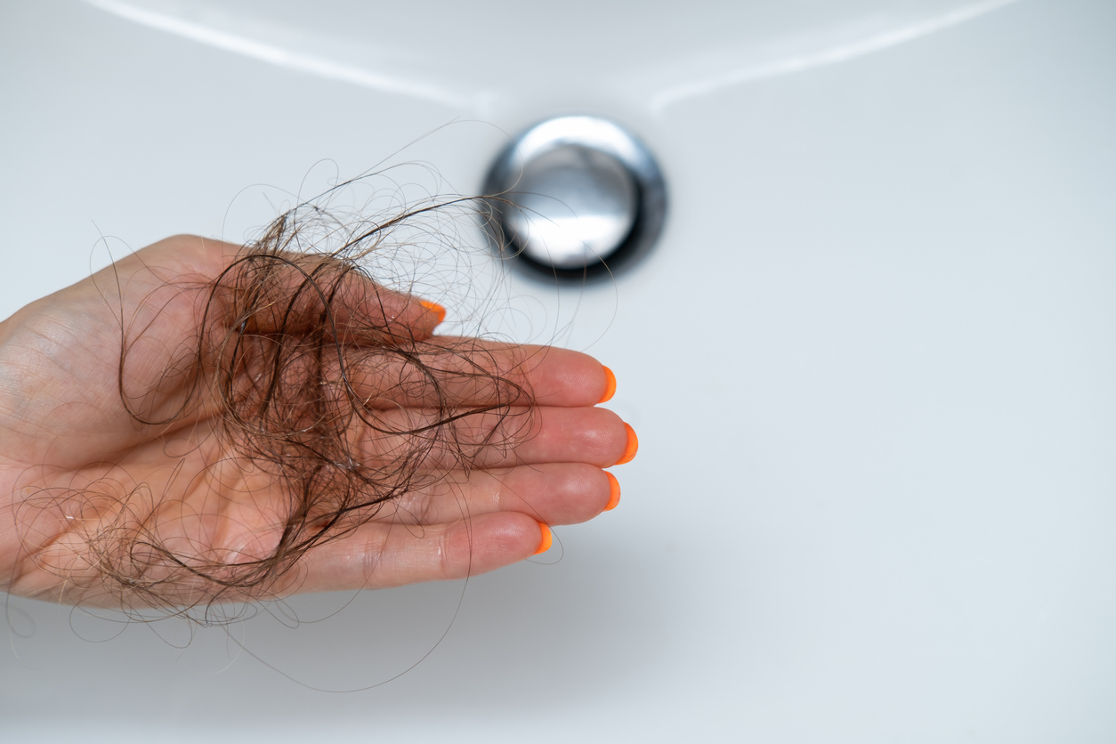 Female hairs in sink. Hair loss concept.