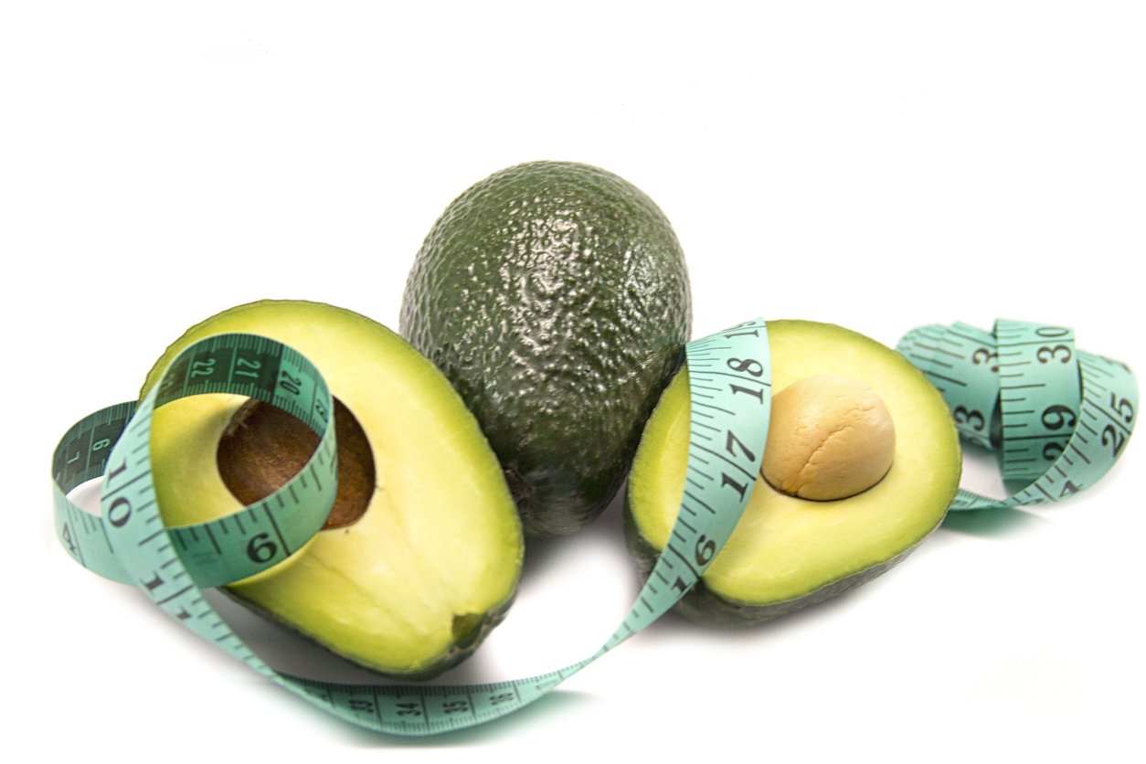 fresh fit avocado on the table with measure tape / avocado
