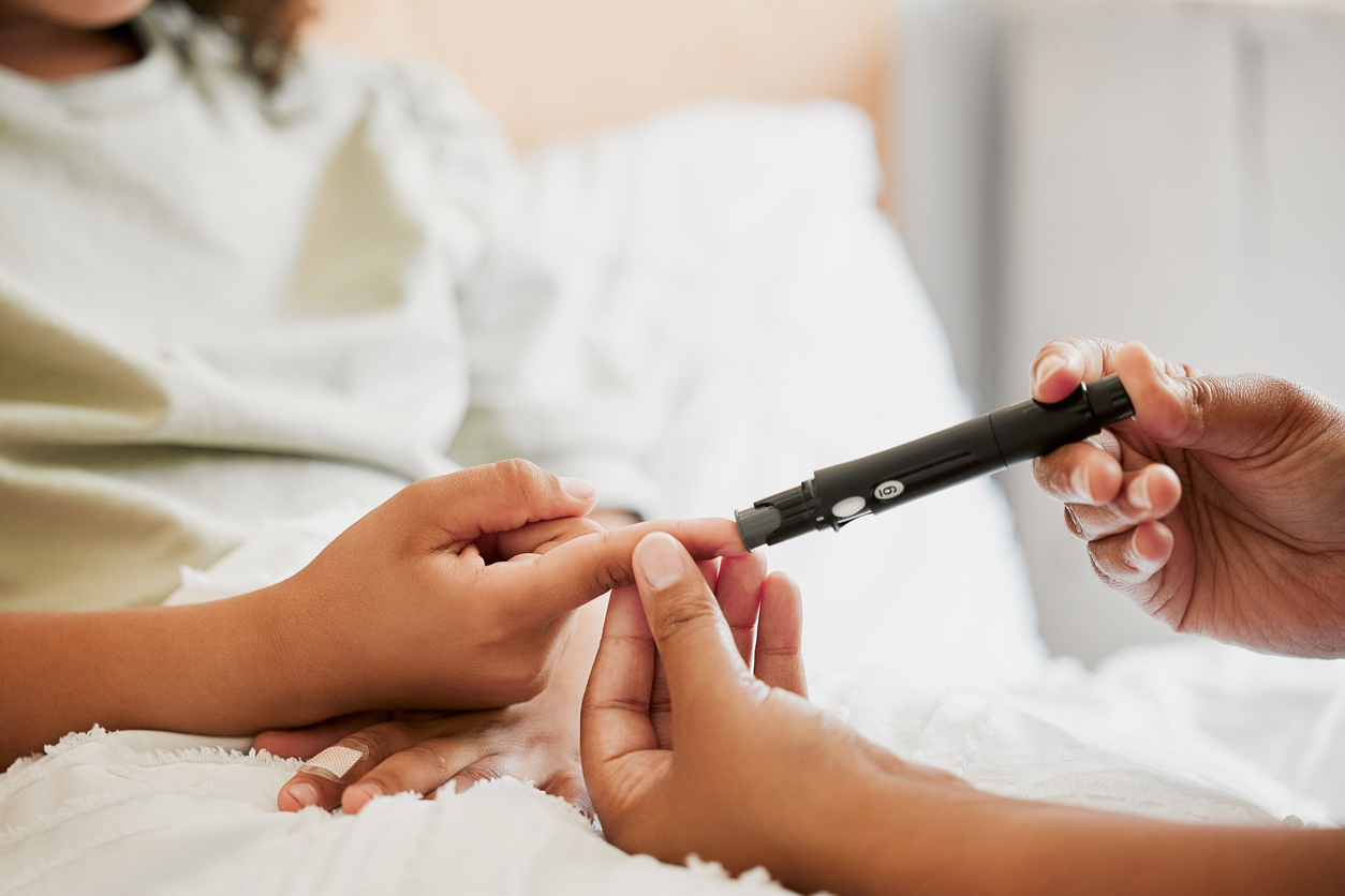 Diabetes, diabetic and mother testing blood sugar levels of a child with a chronic disease at home. Closeup of mom measuring, checking and monitoring glucose in her kid in bed or in the bedroom