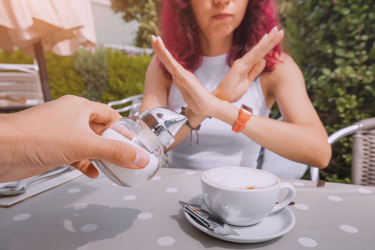 The girl is on a healthy diet and refuses to add sugar to her coffee. The concept of diseases from an excess of fast carbohydrates and diabetes