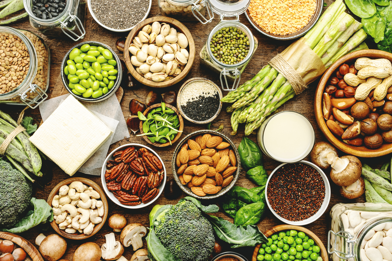 Vegan protein. Full set of plant based vegetarian food sources. Healthy eating, diet ingredients: legumes, beans, lentils, nuts, soy and almond milk, tofu, quinoa, chia, vegetables, spinach, seeds and sprouts. Top view