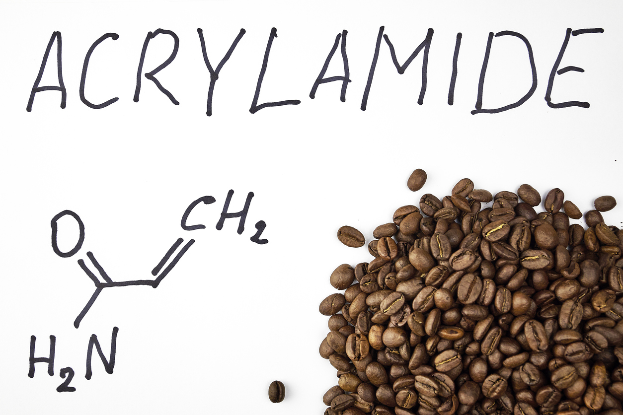 inscription acrylamide chemical formula and black coffee beans containing acrylamide on a white background
