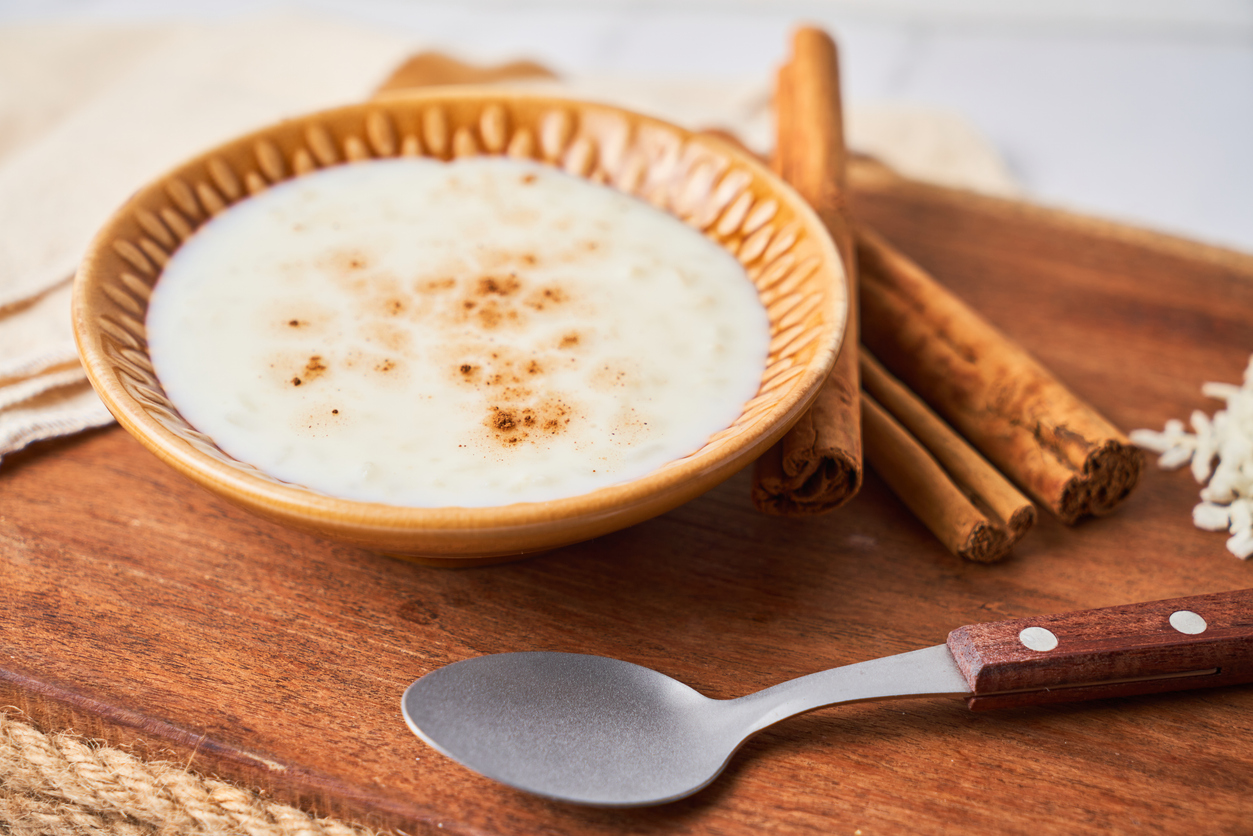 Delicious rice pudding or arroz con leche with cinnamon in bowl on wooden board