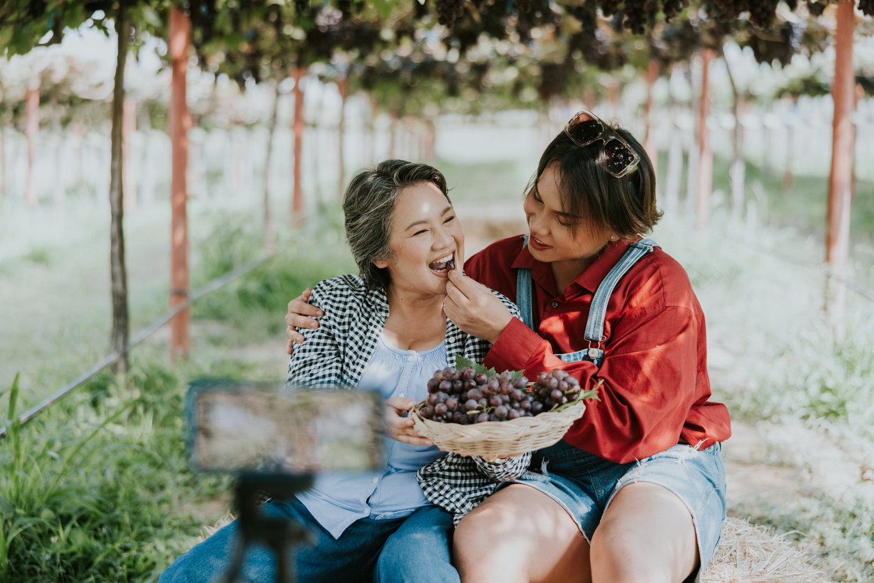 Online marketing, Happy and beautiful son sharing grape products from their vineyard on live streaming and tells their customer that watching her live streaming can orders from now.