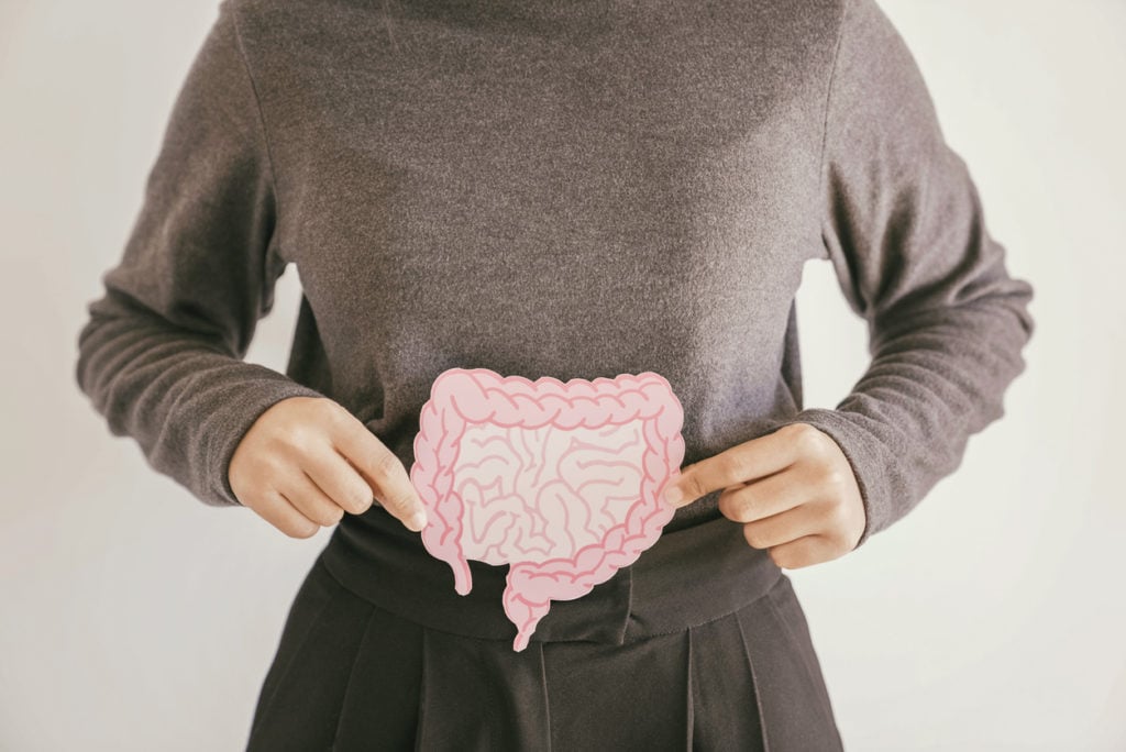 Woman holding intestine shape over her stomach