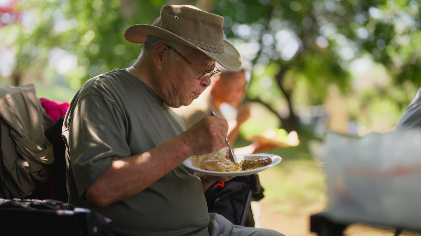 A farming community and family members taking a break from working and having lunch.