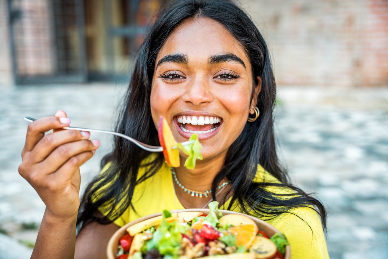 South Asian woman eating a salad