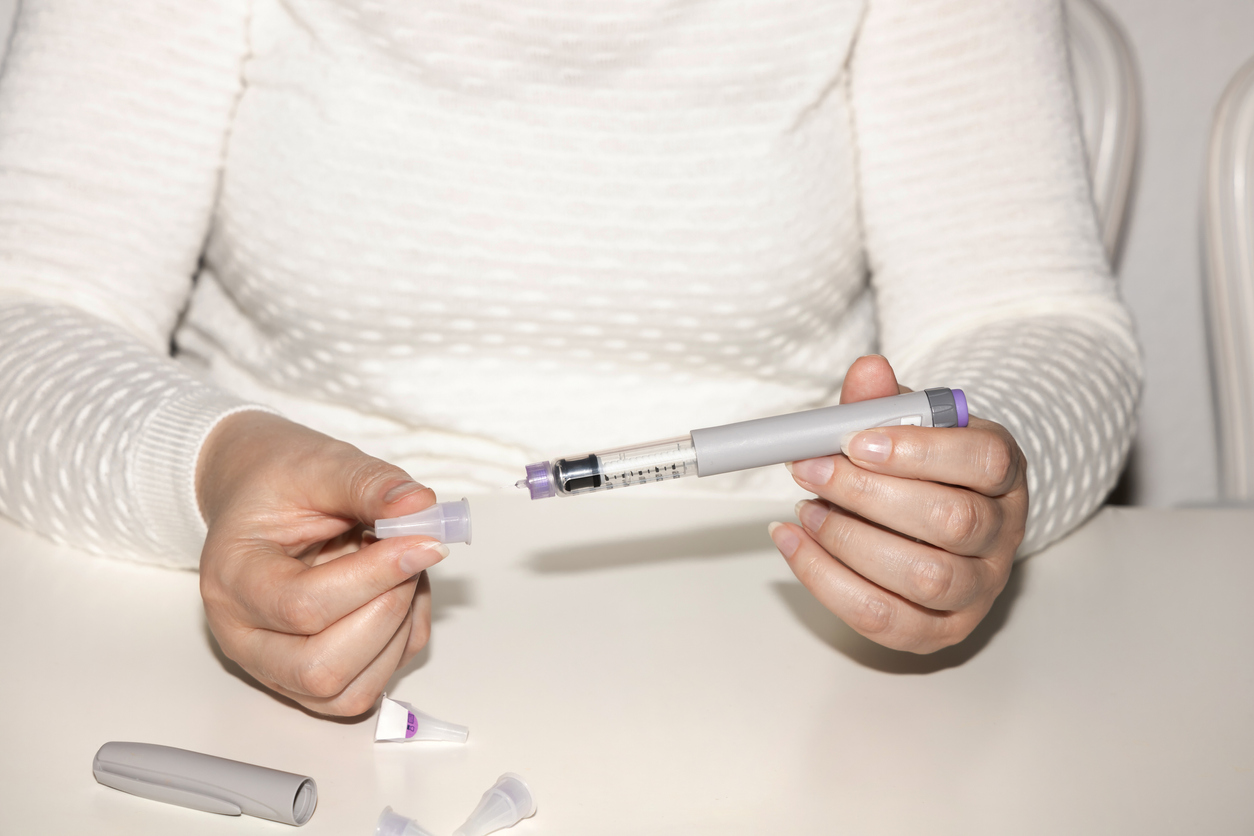 Insulin injection pen or insulin cartridge pen for diabetics. Medical equipment for diabetes parients. Woman holding an injection pen for diabetic.