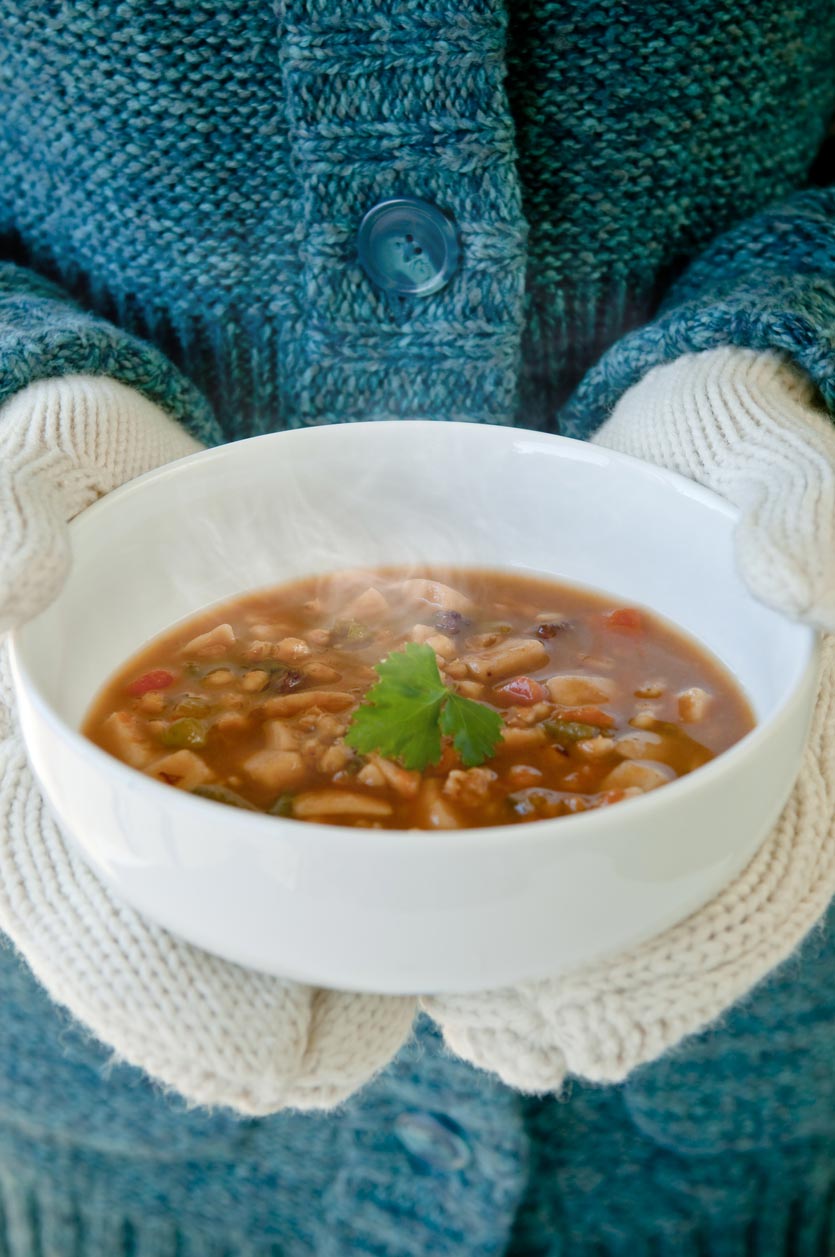 bowl of soup in mittened hands