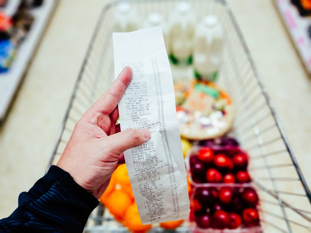 Holding a receipt after buying groceries in the supermarket.