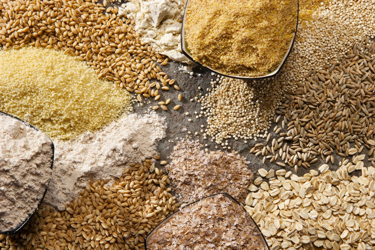 Piles of organic whole grains in different forms.