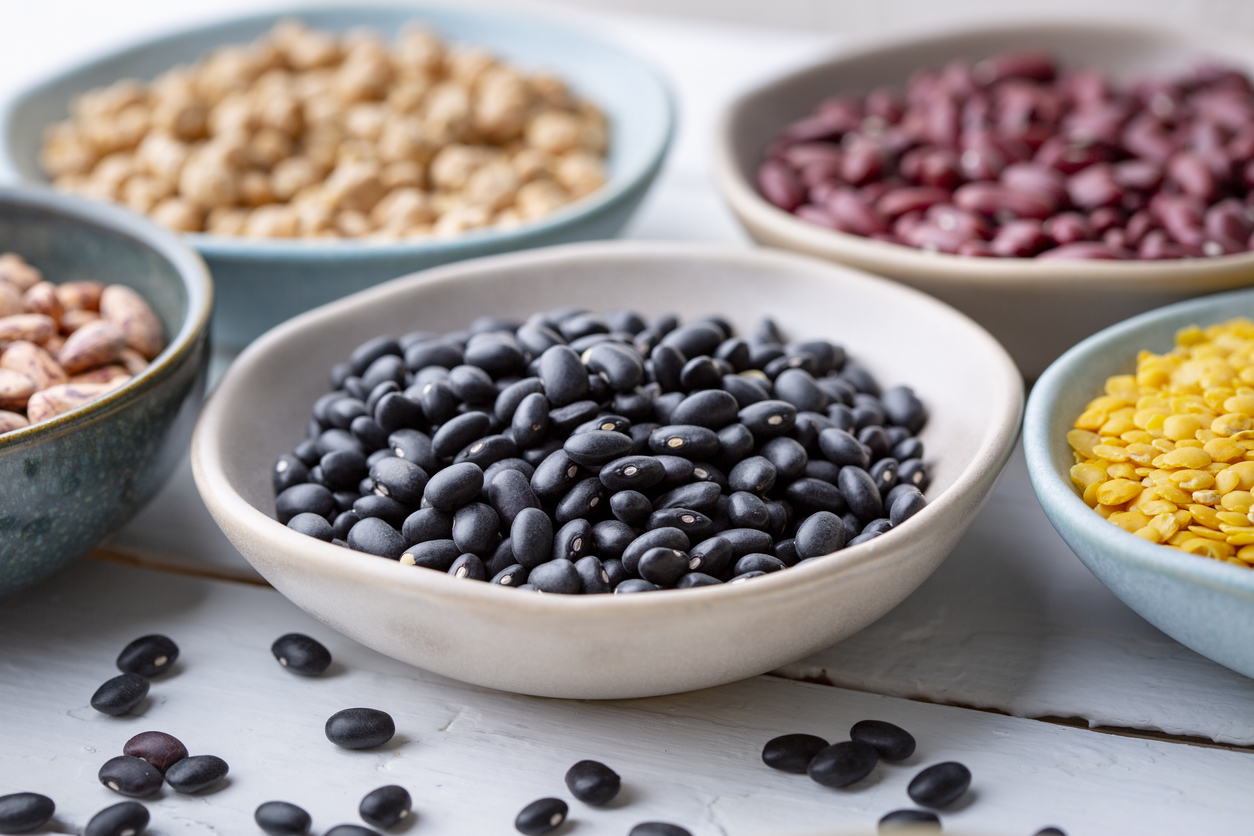 Different types of legumes in bowls - black beans