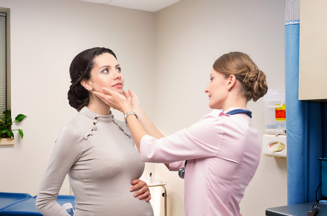 doctor endocrinologist checking thyroid pregnant woman