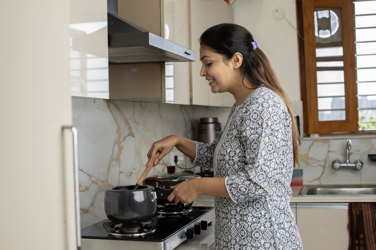 Smiling woman cooking in kitchen at home