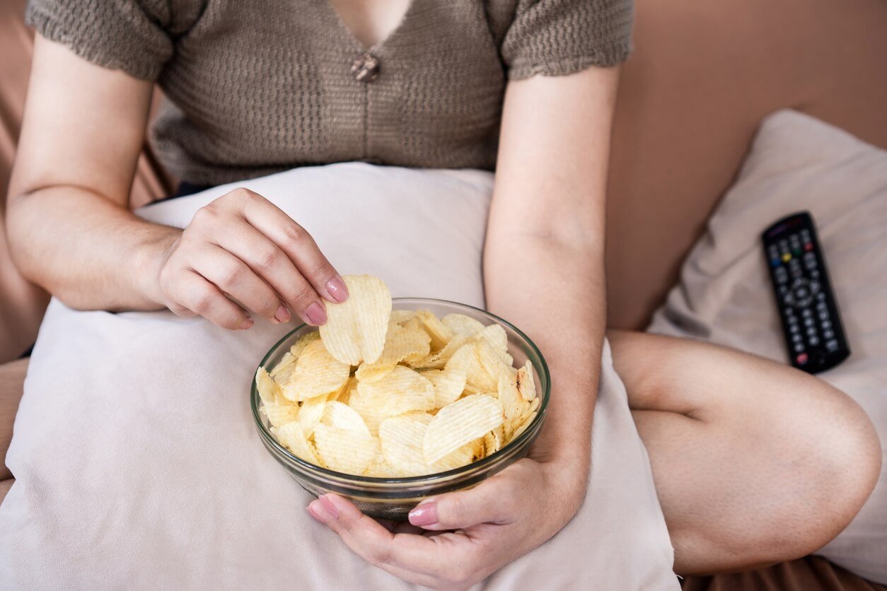 potato-chips-addiction-with-unhealthy-woman-hand-eating-salty-and-oily-potato-fries