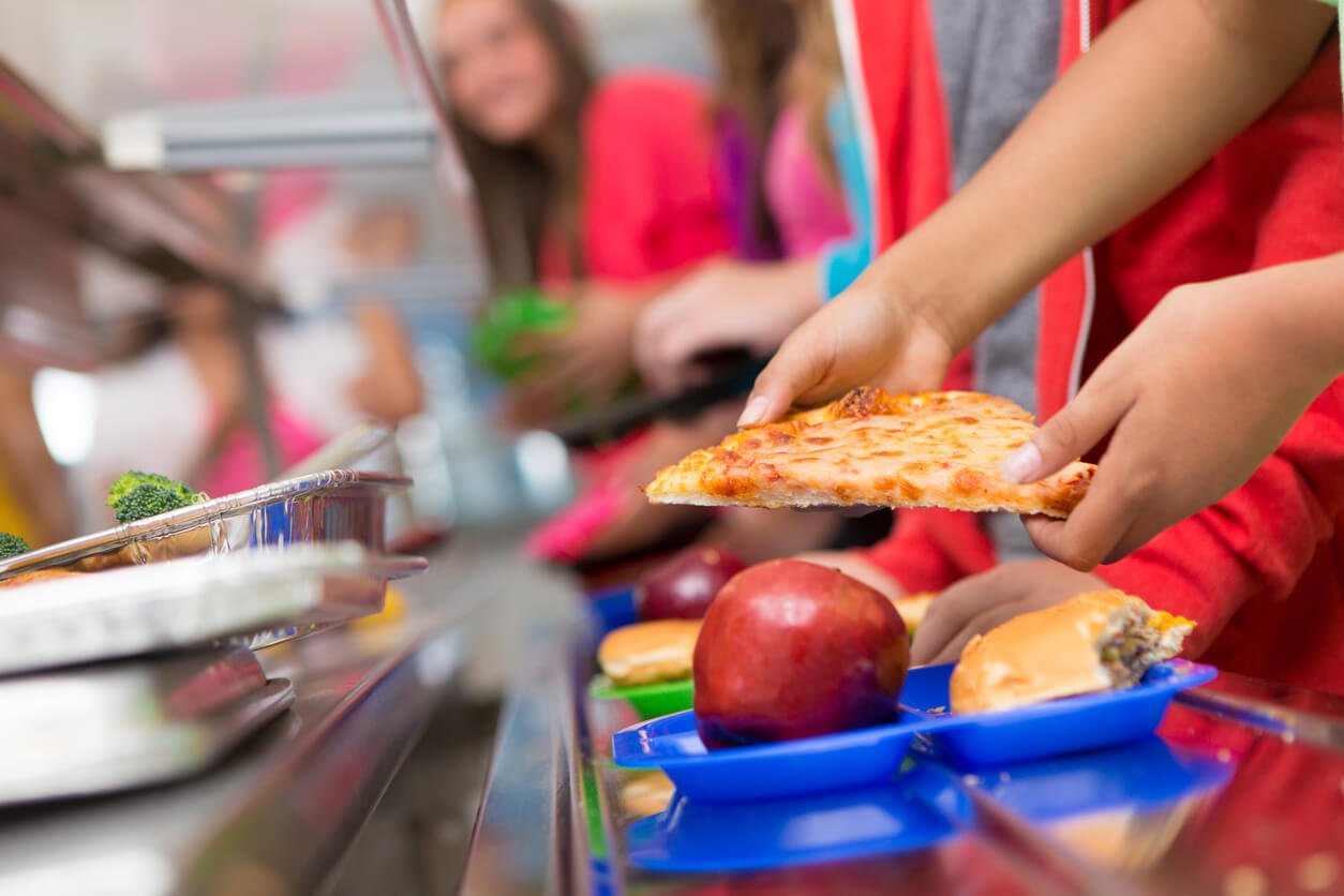 school children getting food in the cafeteria line