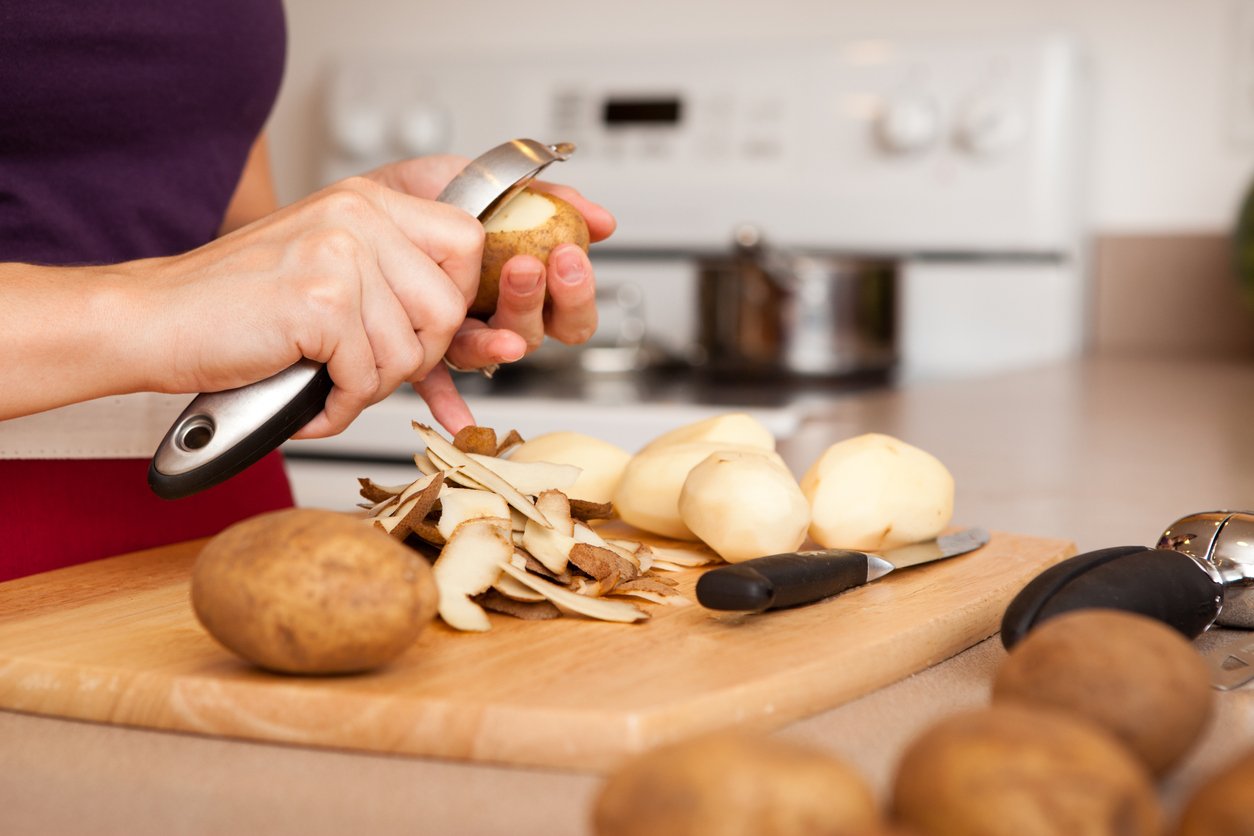 Color Image of Woman Peeling Potatoes in Her Kitchen