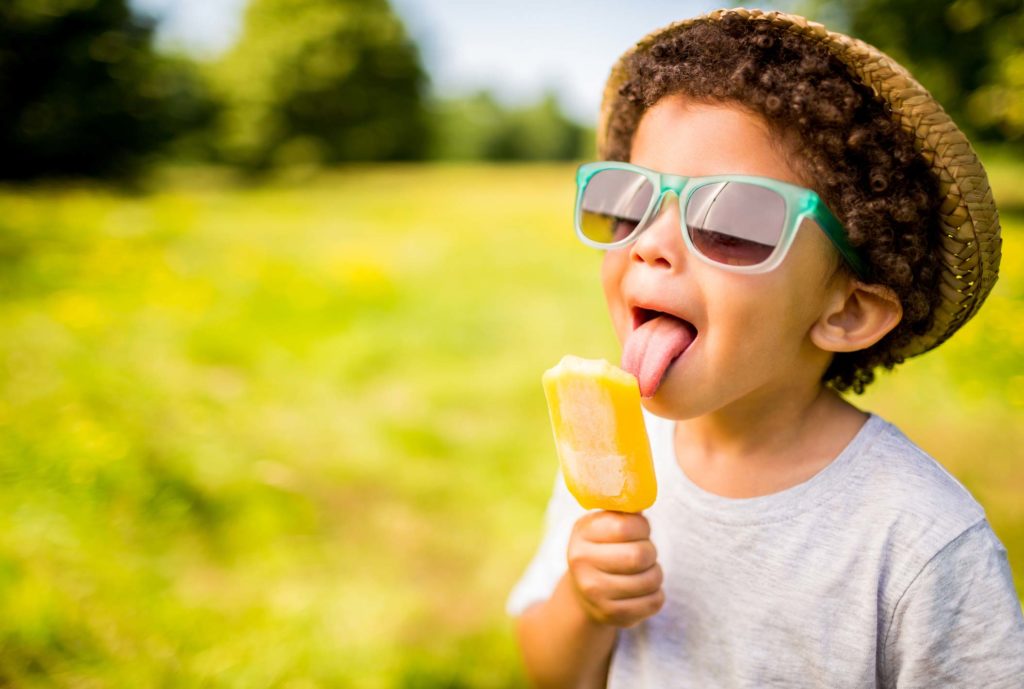 Little boy licking a summertime popsicle