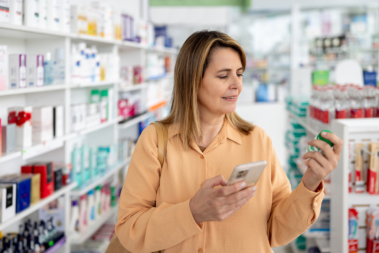 Hispanic woman examining a vitamin supplement in a pharmacy