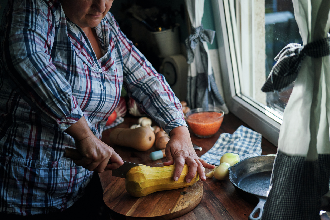 Cutting Butternut Pumpkin on Wooden Board for the Holidays