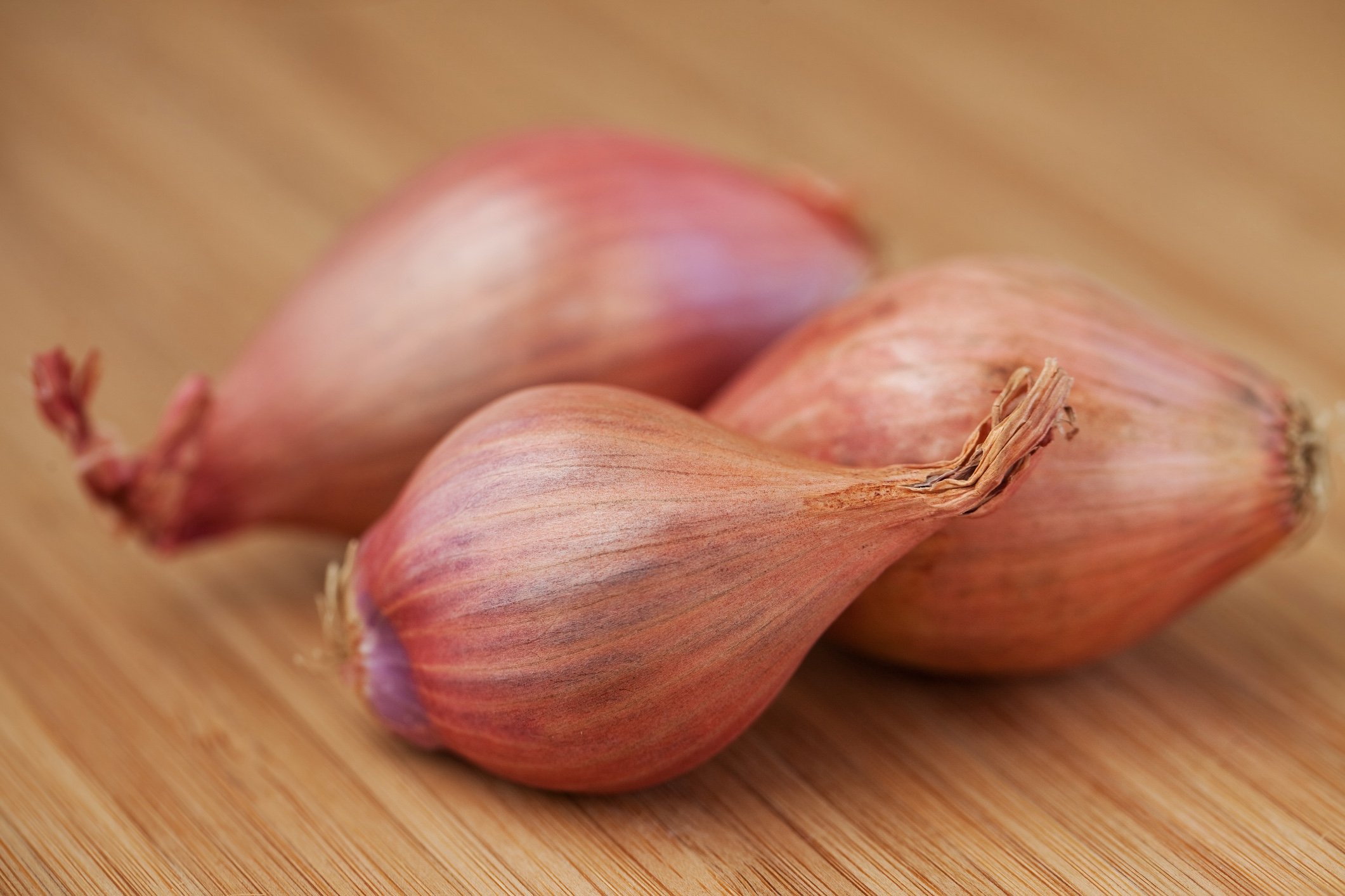 gold onions on wooden table